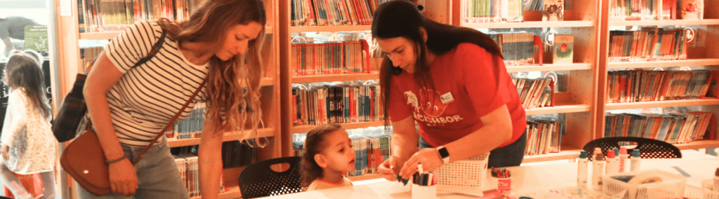 Jessica Carman at Indianapolis Central Library with mom and young girl at craft station
