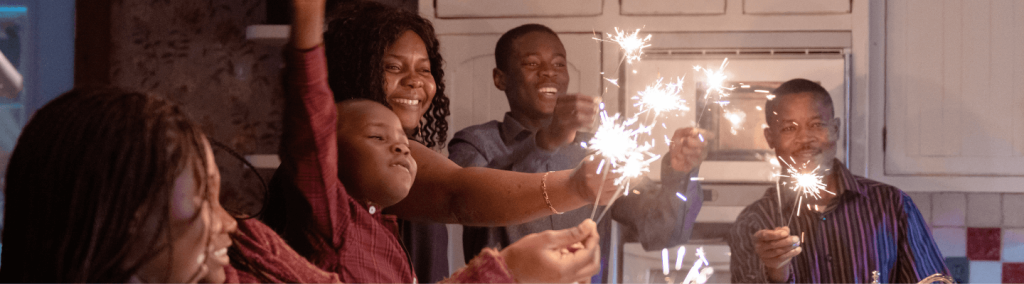 family celebrating with sparklers in their kitchen