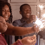 family celebrating with sparklers in their kitchen