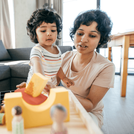 woman playing blocks with toddler