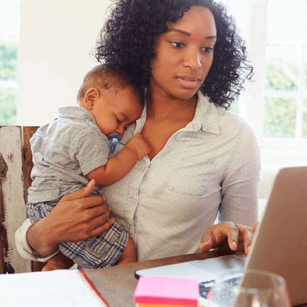 woman on laptop with sleeping baby